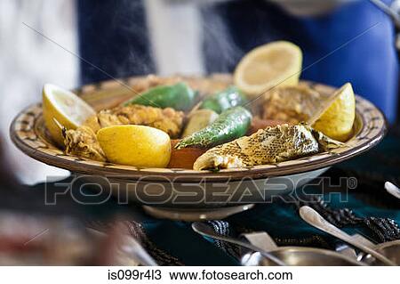 Stock Image - Tunisian restaurant dish of grouper with vegetables, Djerba. Fotosearch