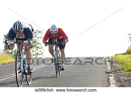 Two cyclists or road, racing downhill View Large Photo Image Stock Image - Two cyclists or road, racing downhill. Fotosearch