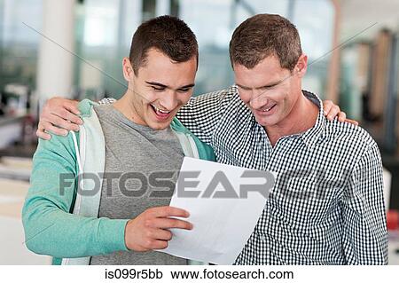 Two men reading document, arms around each other View Large Photo Image Stock Image - Two men reading document, arms around each other. Fotosearch
