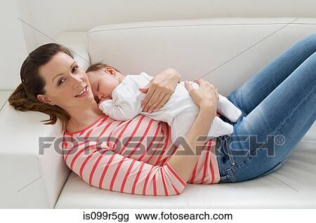 Woman and baby girl resting on sofa View Large Photo Image Stock Image - Woman and baby girl resting on sofa. Fotosearch