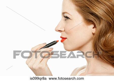 Stock Image - Woman applying red lipstick. Fotosearch