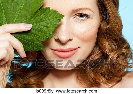 Woman covering eye with green leaf View Large Photo Image Stock Photo - Woman covering eye with green leaf. Fotosearch