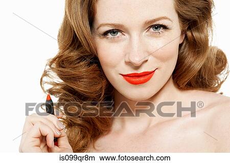 Picture - Woman holding red lipstick. Fotosearch