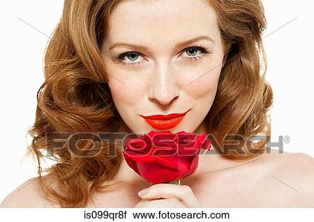 Stock Image - Woman holding red rose. Fotosearch