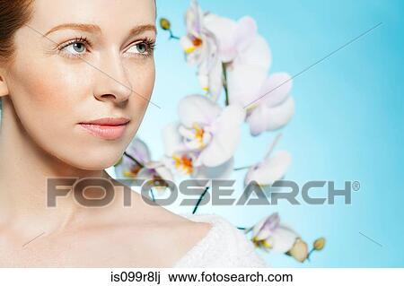 Woman looking away, orchids in background View Large Photo Image Stock Image - Woman looking away, orchids in background. Fotosearch