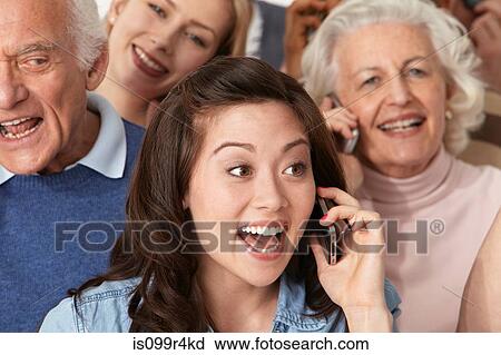 Stock Image - Woman on cell phone with group of people. Fotosearch