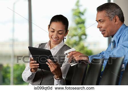 Woman showing man digital tablet View Large Photo Image Stock Image - Woman showing man digital tablet. Fotosearch