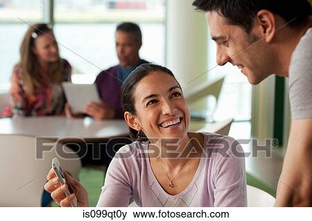 Stock Photo - Woman showing man smartphone. Fotosearch
