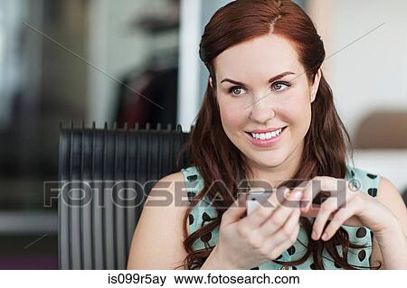 Stock Photo - Woman texting on cell phone. Fotosearch