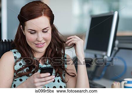 Stock Photo - Woman texting on cell phone. Fotosearch