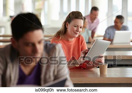 Stock Image - Woman using digital tablet in class. Fotosearch