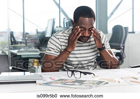 Worried looking man with plans on desk View Large Photo Image Stock Image - Worried looking man with plans on desk. Fotosearch