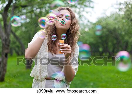 Young woman blowing bubbles View Large Photo Image Stock Photograph - Young woman blowing bubbles. Fotosearch
