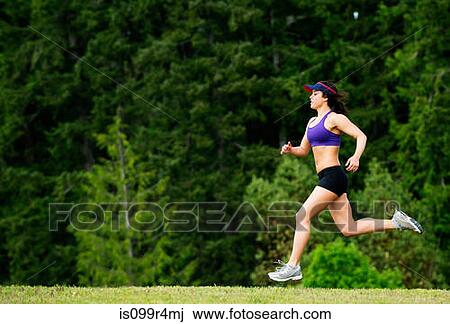 Stock Image - Young woman running in park. Fotosearch