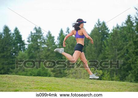 Young woman running in park View Large Photo Image Stock Image - Young woman running in park. Fotosearch