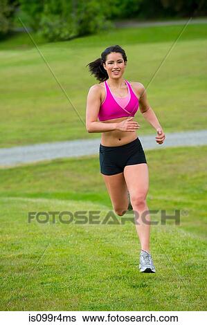 Stock Photograph - Young woman running in park. Fotosearch