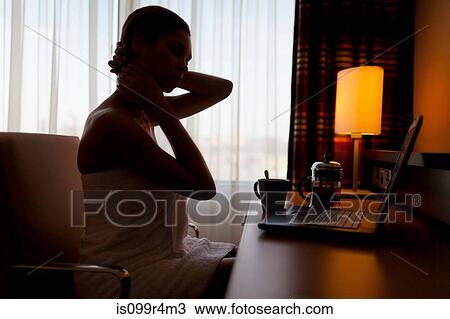 Young woman sitting at laptop in hotel room View Large Photo Image Stock Image - Young woman sitting at laptop in hotel room. Fotosearch