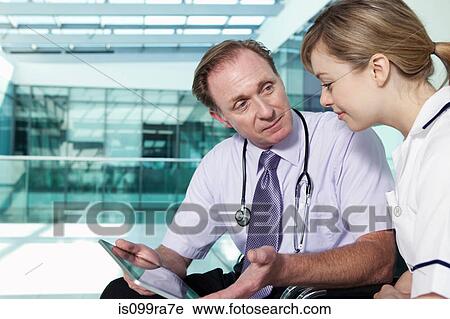 Doctor and nurse with medical records on digital tablet View Large Photo Image Stock Image - Doctor and nurse with medical records on digital tablet. Fotosearch