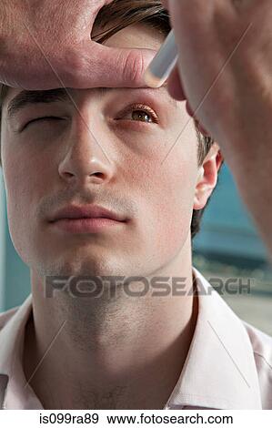 Doctor performing medical examination on patient's eye View Large Photo Image Stock Photo - Doctor performing medical examination on patient's eye. Fotosearch