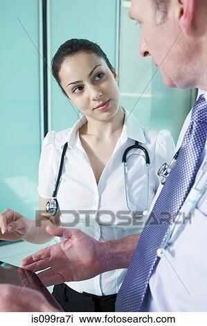 Doctors discussing medical records on digital tablet View Large Photo Image Stock Image - Doctors discussing medical records on digital tablet. Fotosearch