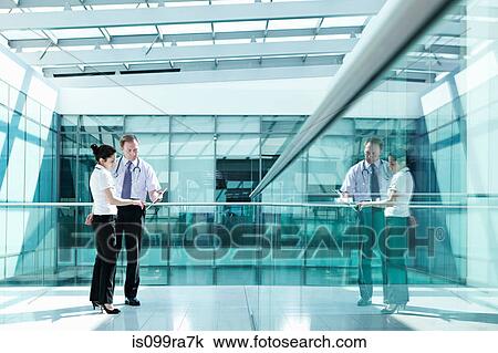 Doctors holding medical records in hospital corridor View Large Photo Image Stock Image - Doctors holding medical records in hospital corridor. Fotosearch