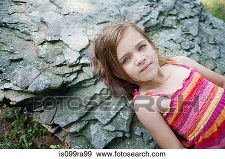 Girl lying on rocks View Large Photo Image Stock Photo - Girl lying on rocks. Fotosearch