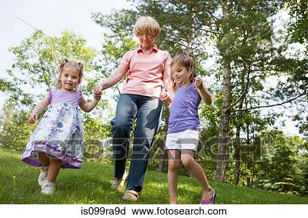 Stock Image - Grandmother and granddaughters holding hands. Fotosearch