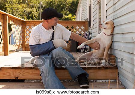 Man outside house with arm in sling and dog View Large Photo Image Stock Photo - Man outside house with arm in sling and dog. Fotosearch