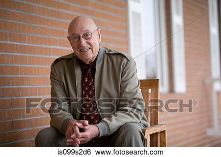 Man sitting on chair, portrait View Large Photo Image Stock Photograph - Man sitting on chair, portrait. Fotosearch