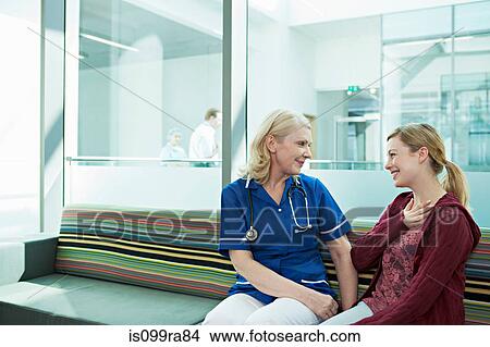 Nurse talking to woman in hospital waiting room View Large Photo Image Picture - Nurse talking to woman in hospital waiting room. Fotosearch