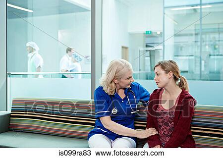 Nurse talking to woman in hospital waiting room View Large Photo Image Stock Image - Nurse talking to woman in hospital waiting room. Fotosearch