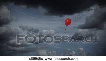 Stock Photograph - Red balloon floating through dark sky. Fotosearch