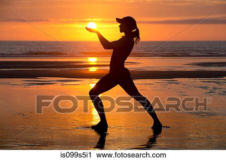 Silhouette of young woman by the sea at sunset, holding the sun View Large Photo Image Stock Image - Silhouette of young woman by the sea at sunset, holding the sun. Fotosearch