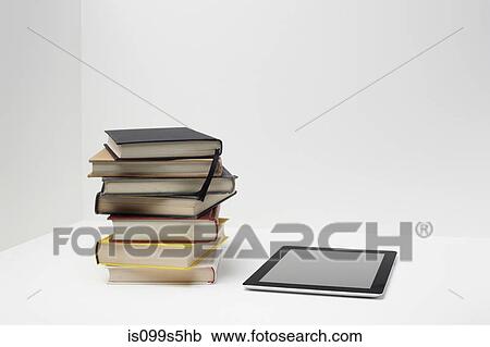 Stack of books with digital tablet View Large Photo Image Stock Image - Stack of books with digital tablet. Fotosearch