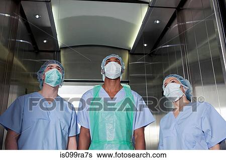 Three surgeons in hospital elevator View Large Photo Image Stock Photograph - Three surgeons in hospital elevator. Fotosearch