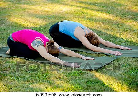 Two women stretching on yoga mats outdoors View Large Photo Image Stock Photograph - Two women stretching on yoga mats outdoors. Fotosearch