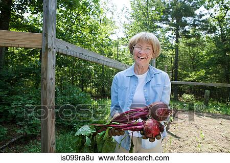 Stock Photograph - Woman holding beetroot. Fotosearch