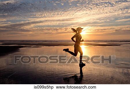 Woman running on beach at sunrise View Large Photo Image Stock Photography - Woman running on beach at sunrise. Fotosearch