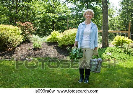 Woman with watering can and beetroot in garden View Large Photo Image Stock Photo - Woman with watering can and beetroot in garden. Fotosearch