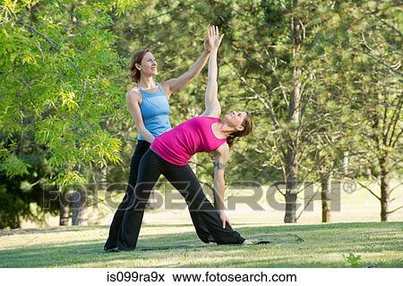 Yoga instructor and student in park View Large Photo Image Stock Photo - Yoga instructor and student in park. Fotosearch