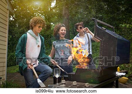Stock Photograph - Young adult friends enjoying a backyard barbecue. Fotosearch