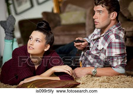 Young couple watching televsion View Large Photo Image Stock Photo - Young couple watching televsion. Fotosearch