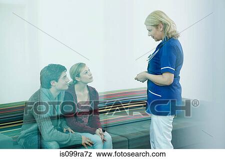 Young couple with nurse in hospital waiting room View Large Photo Image Stock Photo - Young couple with nurse in hospital waiting room. Fotosearch