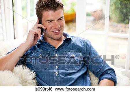 Young man using smartphone View Large Photo Image Stock Photograph - Young man using smartphone. Fotosearch