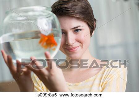 Young woman holding goldfish in a bowl View Large Photo Image Stock Photography - Young woman holding goldfish in a bowl. Fotosearch