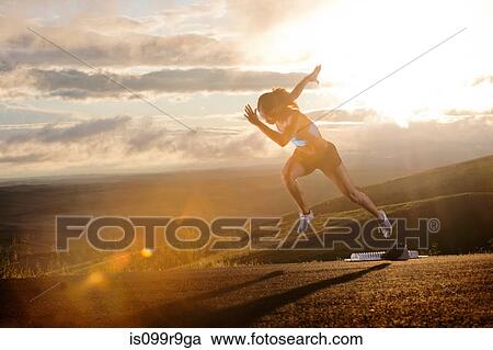 Young woman moving off starting blocks in rural setting View Large Photo Image Stock Image - Young woman moving off starting blocks in rural setting. Fotosearch