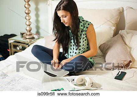 Young woman on bed with laptop View Large Photo Image Stock Image - Young woman on bed with laptop. Fotosearch
