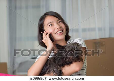 Young woman on cellphone with pet dog View Large Photo Image Stock Photo - Young woman on cellphone with pet dog. Fotosearch