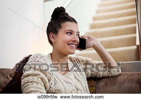 Young woman on sofa using smartphone View Large Photo Image Stock Photo - Young woman on sofa using smartphone. Fotosearch