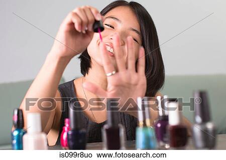 Young woman painting her fingernails View Large Photo Image Picture - Young woman painting her fingernails. Fotosearch